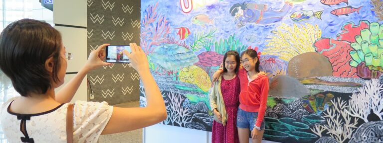 Picture of two children having a photograph take in front of AG Saño's art installation at ADEX.