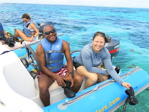 Picture of members of the Green Fins Antigua & Barbuda team on a boat, smiling at the camera. 