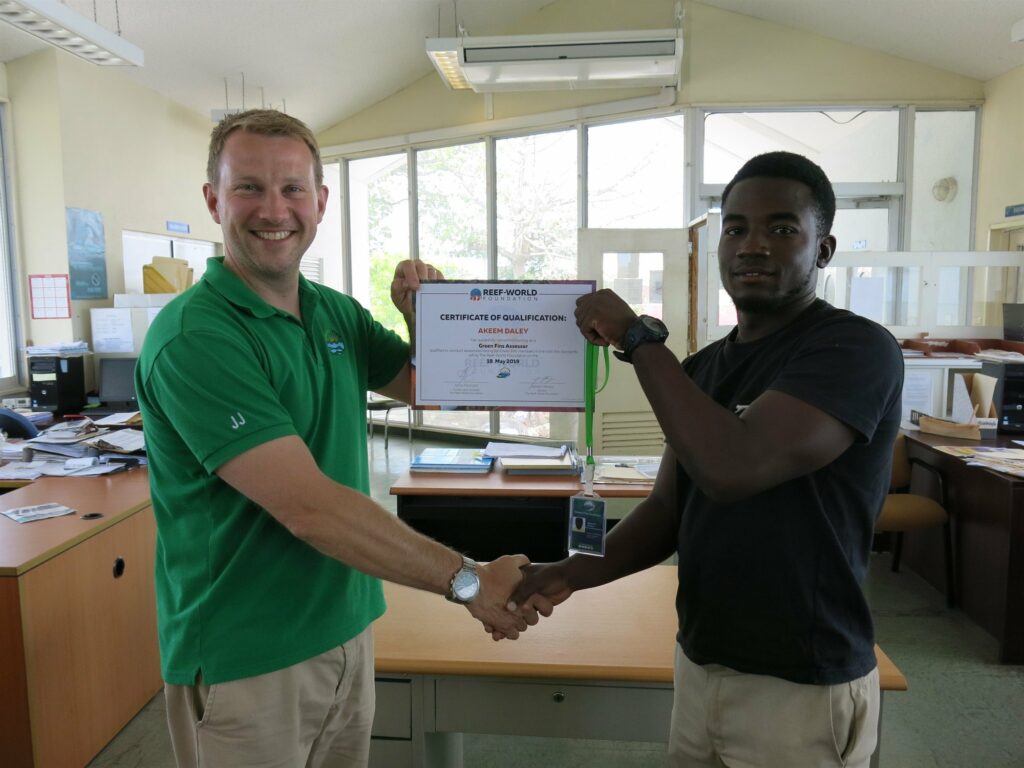 Picture of Reef-World Director JJ Harvey presenting a certificate to a member of the Green Fins team. 