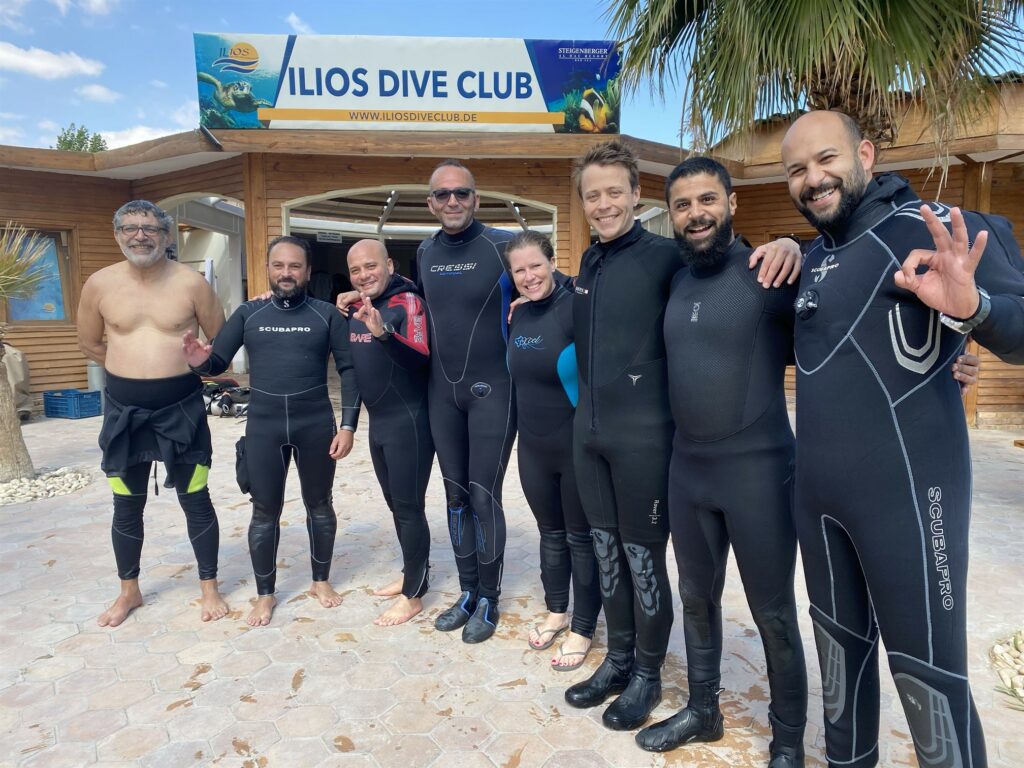 Picture of the Reef-World team with assessors standing outside Ilios Dive Club. 