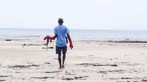 Picture of some taking part in a beach clean. 