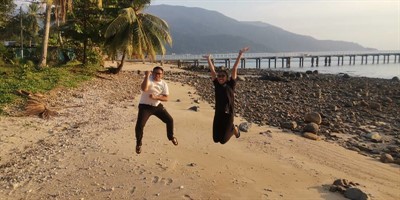 Picture of newly certified Green Fins assessors jumping for joy on the beach