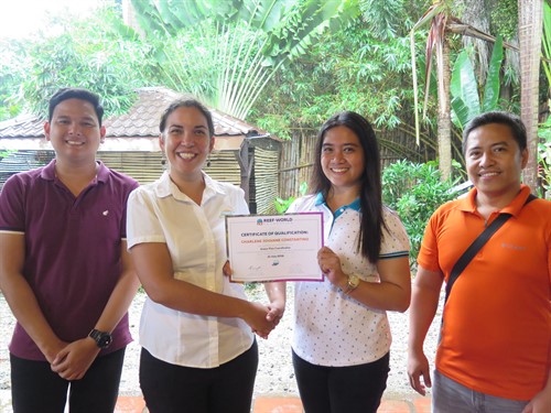 Picture of Sam from Reef-World presenting a certificate to members of the Green Fins team. 