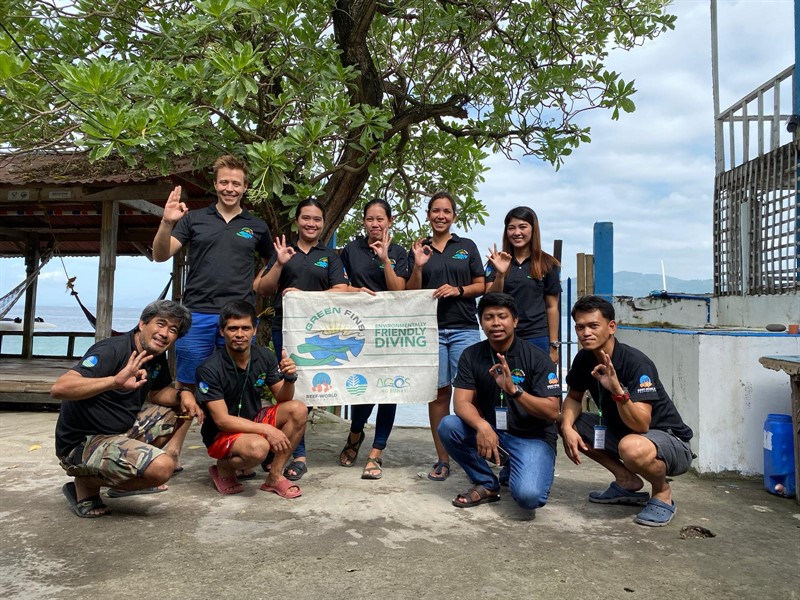 Picture of James and Sam from Reef-World with a Green Fins assessors. They are making the 'OK' hand signal. 