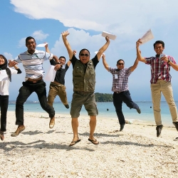 Picture of the Green Fins Malaysia team celebrating with their certificates on a beach. 