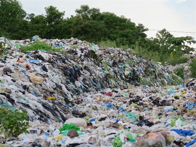 Picture of a landscape covered in hundreds of single-use plastic items. 