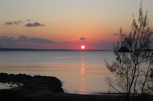 Picture of a sunset over the ocean in Onna Village. 