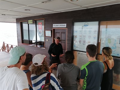 Picture of a Scuba Junkie instructor talking a group of people through the Green Fins guidelines. 