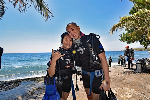 Picture of two divers on a beach. 