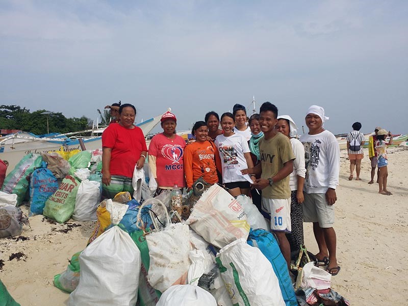 Picture of a beach clean-up team with trash collected from the beach. 