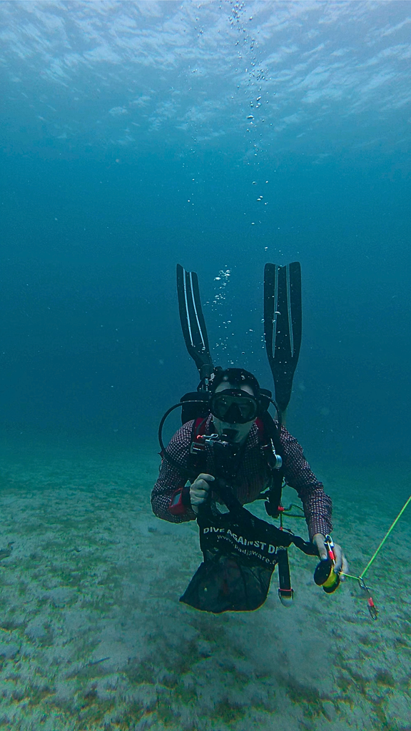 A scuba diver carrying a Dive against Debris collection bag during an underwater clean up