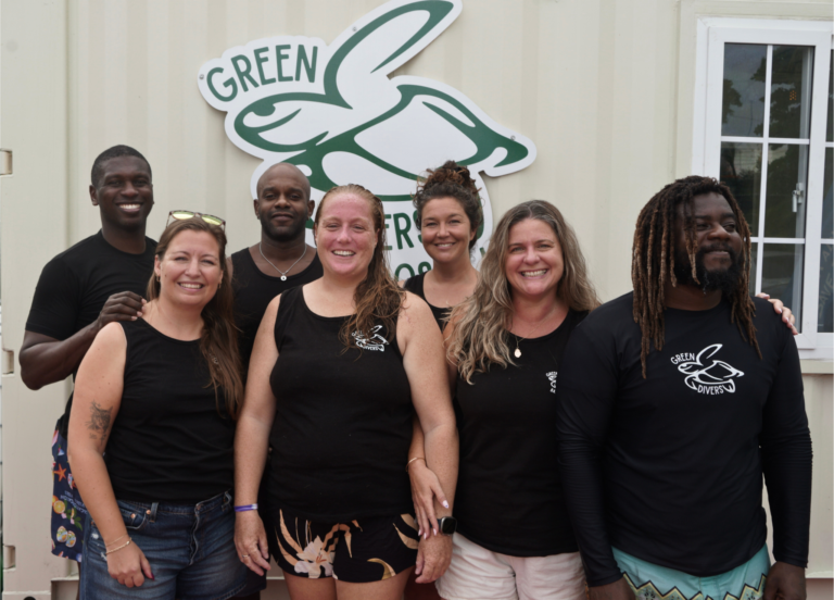 Green Divers Barbados Team in front of their logo